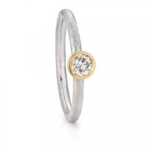 Hammered textured diamond engagement ring with a 25 carat round diamond, set into a yellow gold setting. Handmade by Bristol jeweller Jacks Turner.