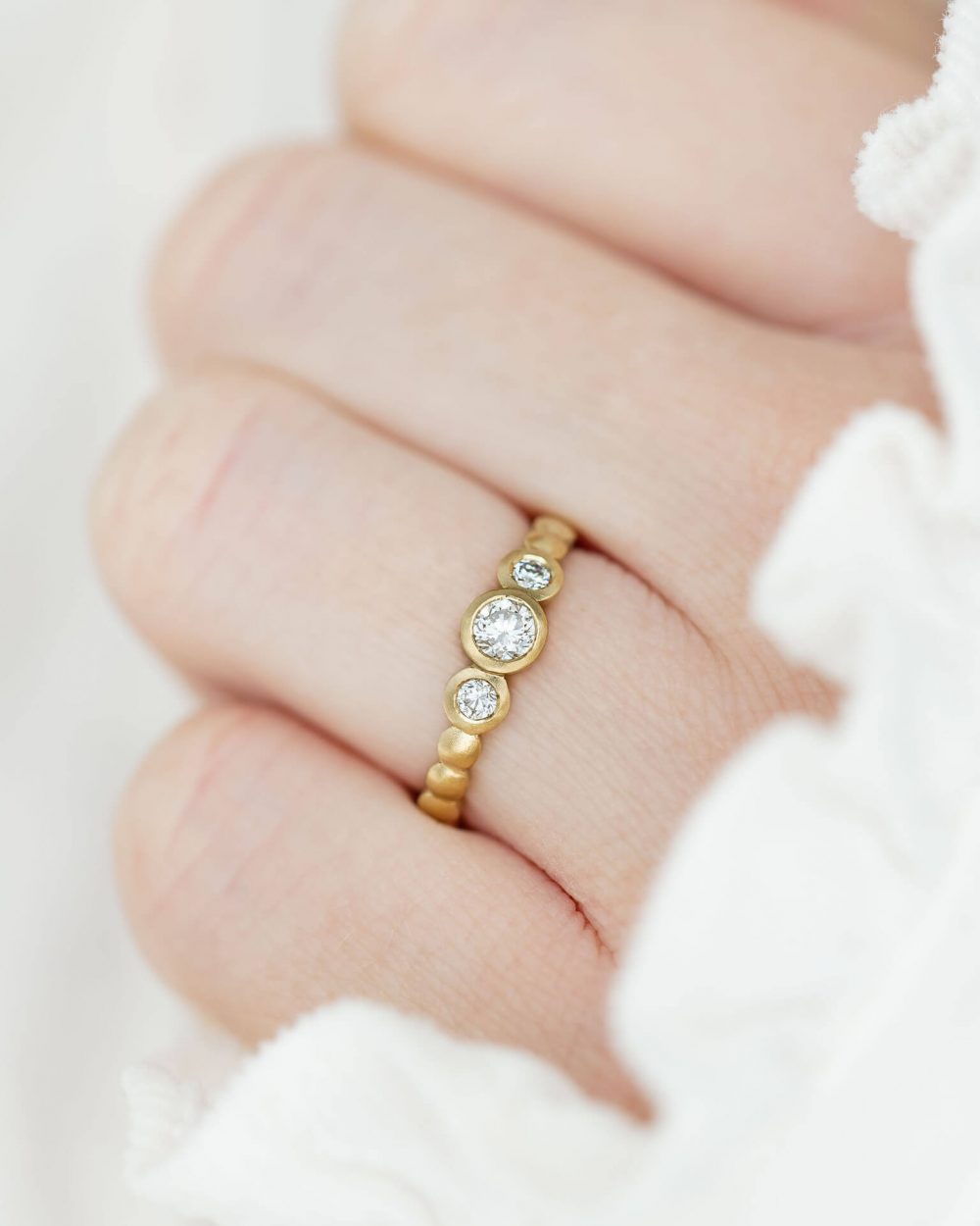 Trio Diamond Engagement Ring In Yellow Gold, Worn On Model. Designed By Bristol Jeweller Jacks Turner.