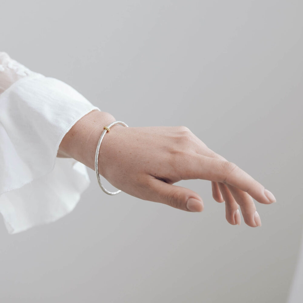 Eternity Silver Bangle With Gold Diamond Bead On Model. Designed By Bristol Contemporary Jeweller Jacks Turner.