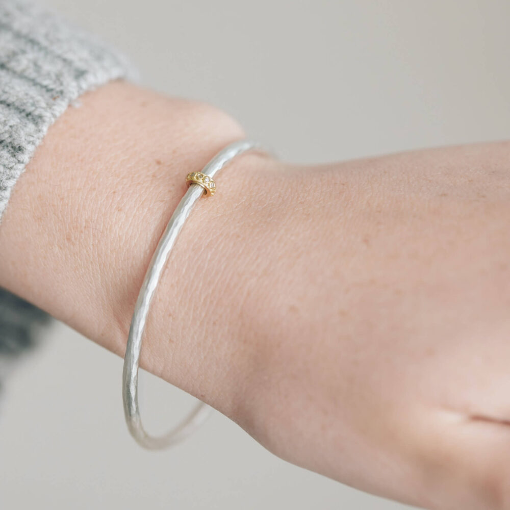 Eternity Silver Bangle With Gold Diamond Bead On Model. Designed By Bristol Contemporary Jeweller Jacks Turner.